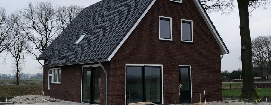 Mooi bruin huis met een stuk land erachter.